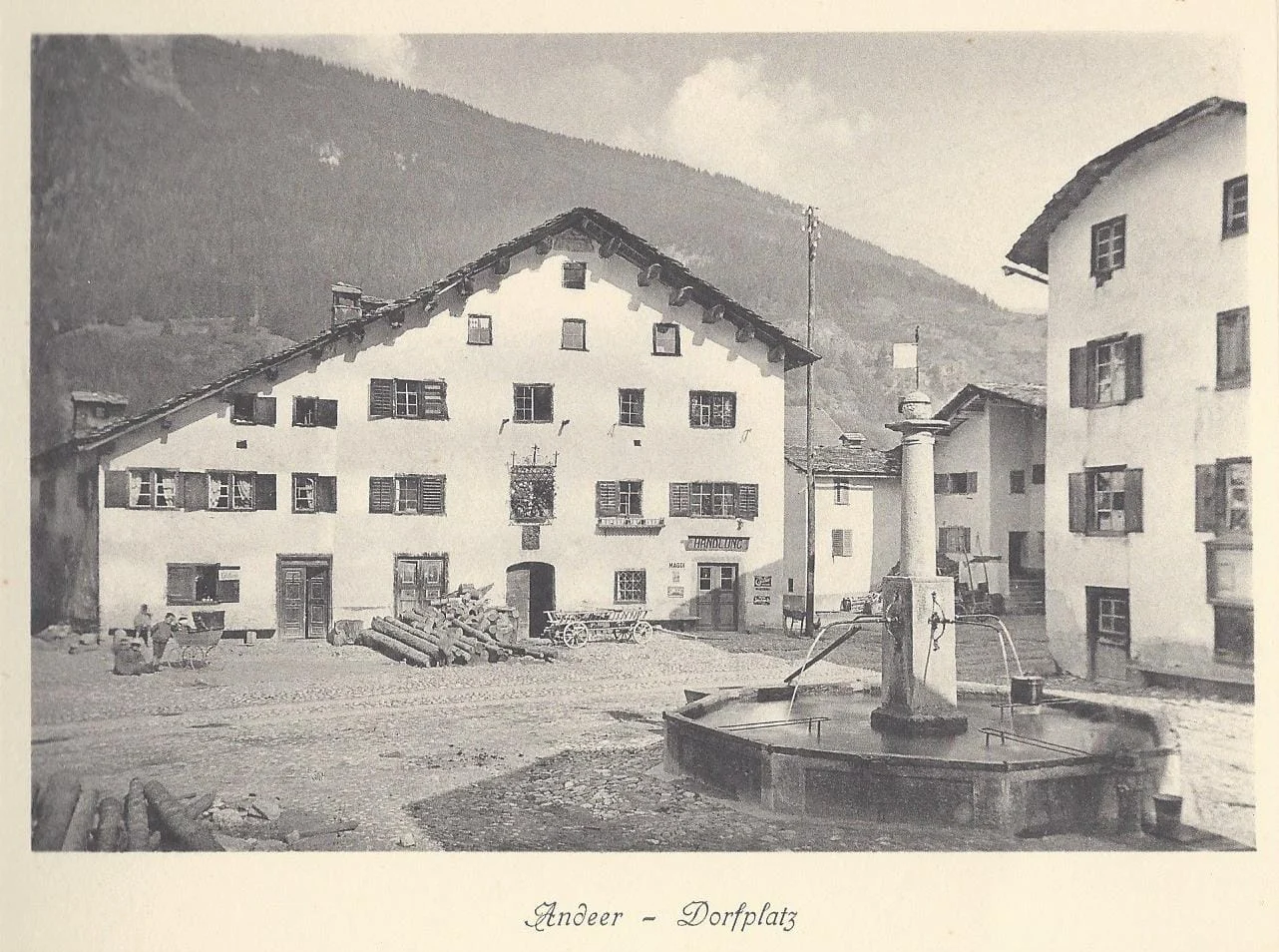 Dorfplatz Andeer mit Brunnen und Weissem Kreuz